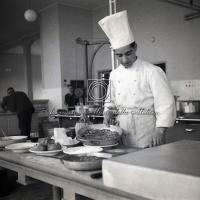 Cuoco al lavoro nelle cucine della mensa